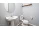 Powder room featuring a pedestal sink, round mirror, and modern fixtures at 2321 W Brookhart Way, Phoenix, AZ 85085