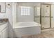 Bathroom with soaking tub, glass block window, and glass door shower with gold trim at 2723 N Winthrop --, Mesa, AZ 85213