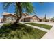 Charming two-story home boasts a three car garage, landscaped yard, and desert tree at 2723 N Winthrop --, Mesa, AZ 85213