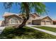Charming two-story home boasts a three car garage, landscaped yard, and desert tree at 2723 N Winthrop --, Mesa, AZ 85213