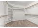 Spacious walk-in closet with custom built-in shelves and wooden rods for storage at 2723 N Winthrop --, Mesa, AZ 85213
