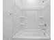 Clean, bright bathroom featuring a bright tub and shower with shelving at 37153 W Prado St, Maricopa, AZ 85138