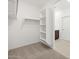 Walk in closet with shelves, hanging space and a view to the primary bathroom at 37153 W Prado St, Maricopa, AZ 85138