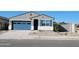Charming single-story home featuring a blue garage door and decorative blue shutters at 37153 W Prado St, Maricopa, AZ 85138