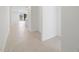 Bright hallway showcasing neutral tile flooring leading into an open-concept living area with a kitchen island at 37153 W Prado St, Maricopa, AZ 85138