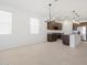 Open floorplan featuring a modern kitchen, dining area, tile flooring, and natural light at 37153 W Prado St, Maricopa, AZ 85138