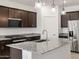 Close-up of kitchen island with granite countertops, stainless steel appliances, and modern fixtures at 37153 W Prado St, Maricopa, AZ 85138