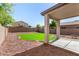 A cozy backyard with a well-maintained lawn, an extended patio, and desert landscaping at 379 E Cheyenne Rd, San Tan Valley, AZ 85143