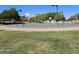 Well-maintained community basketball court with multiple hoops surrounded by green grass and trees at 379 E Cheyenne Rd, San Tan Valley, AZ 85143