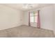 Well-lit bedroom featuring carpet floors, a ceiling fan, window with curtains, and white walls at 379 E Cheyenne Rd, San Tan Valley, AZ 85143