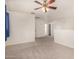 View of a spacious bedroom featuring neutral carpet, ceiling fan, and access to a bathroom at 379 E Cheyenne Rd, San Tan Valley, AZ 85143