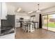 Open kitchen boasts white cabinets, stainless appliances, island with seating, and access to the backyard at 379 E Cheyenne Rd, San Tan Valley, AZ 85143