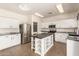 Bright kitchen with stainless steel appliances, an island with seating, and white cabinets at 379 E Cheyenne Rd, San Tan Valley, AZ 85143