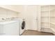 A well-equipped laundry room with tiled floor, shelving, and modern washer and dryer units at 379 E Cheyenne Rd, San Tan Valley, AZ 85143