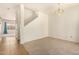 This carpeted room shows the staircase, a chandelier, and a glimpse into another room at 379 E Cheyenne Rd, San Tan Valley, AZ 85143