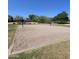 Outdoor sand volleyball court ready for a match, framed by greenery and blue skies at 379 E Cheyenne Rd, San Tan Valley, AZ 85143