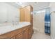 Bathroom vanity featuring granite counters, wood cabinets, a sink, and a shower with tub at 3833 W Phelps Rd, Phoenix, AZ 85053