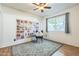 A bright bedroom featuring wood floors, ceiling fan, an accent wall, and a window at 3833 W Phelps Rd, Phoenix, AZ 85053