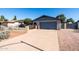 Home featuring a two-car garage with a well-maintained concrete driveway and manicured front yard at 3833 W Phelps Rd, Phoenix, AZ 85053