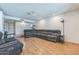 Spacious living room featuring an L-shaped reclining sofa and laminate wood floors at 3833 W Phelps Rd, Phoenix, AZ 85053