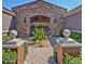 Grand stone entrance with wrought iron gate and landscaped pathway at 3935 E Rough Rider Rd # 1360, Phoenix, AZ 85050
