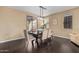 Warm dining room area features a chandelier, a dining table with upholstered chairs, and dark wood floors at 3964 E Hummingbird Ln, Phoenix, AZ 85050