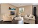 Comfortable living room with fireplace, plush seating, hardwood floors, and a sunny window at 3964 E Hummingbird Ln, Phoenix, AZ 85050