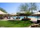 Community pool with shaded seating areas and lush green landscaping at 3964 E Hummingbird Ln, Phoenix, AZ 85050
