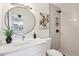 Stylishly updated bathroom featuring sleek fixtures, a new vanity, a round mirror, and a walk-in tiled shower at 4117 W Camino Acequia Ave, Phoenix, AZ 85051