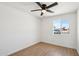 Clean bedroom with ceiling fan, light wood floors and a sunlit window overlooking the neighborhood at 4117 W Camino Acequia Ave, Phoenix, AZ 85051