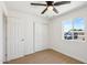 Well-lit bedroom featuring wood-look floors, a ceiling fan, and a double-door closet for ample storage at 4117 W Camino Acequia Ave, Phoenix, AZ 85051