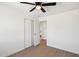 Cozy bedroom features light wood flooring, a ceiling fan and an easy access to another room at 4117 W Camino Acequia Ave, Phoenix, AZ 85051
