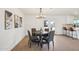 Dining area with wood table, chairs and lighting fixture, with a view to an open-concept kitchen with white cabinets at 4117 W Camino Acequia Ave, Phoenix, AZ 85051