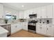 Updated kitchen with stainless steel appliances, white cabinets, and light-colored countertops at 4117 W Camino Acequia Ave, Phoenix, AZ 85051