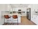 Modern kitchen featuring white cabinets, stainless steel appliances, and a breakfast bar with seating at 4117 W Camino Acequia Ave, Phoenix, AZ 85051