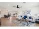 Inviting living room with wood-look floors, neutral decor, a ceiling fan, and an open layout connected to dining area at 4117 W Camino Acequia Ave, Phoenix, AZ 85051