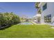 Spacious backyard with a sparkling pool, manicured lawn, dining area, and modern home exterior at 4120 N 44Th Pl, Phoenix, AZ 85018