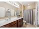 Bright bathroom featuring a spacious vanity, with a shower-tub combo, offering both style and functionality, with tile flooring at 4553 W Kirkland Ave, San Tan Valley, AZ 85144