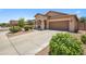 Tan single-story home with well-maintained landscaping and a two-car garage with large driveway at 4553 W Kirkland Ave, San Tan Valley, AZ 85144