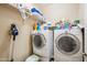 Efficient laundry room equipped with modern appliances and storage shelves, and tile flooring for easy clean-up at 4553 W Kirkland Ave, San Tan Valley, AZ 85144