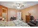 Bright bedroom boasts neutral tones, with an ensuite bathroom, carpet flooring, fan, and ample space for furniture arrangement at 4553 W Kirkland Ave, San Tan Valley, AZ 85144