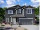 Charming two-story home features a stone-accented facade, a covered porch, and a two-car garage at 5681 E Iris Dr, Florence, AZ 85132