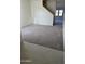 Open concept living space with stairs, neutral walls, and gray carpeting flowing from tiled entry at 5701 E Iris Dr, Florence, AZ 85132
