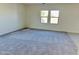 Bright living room featuring neutral carpet, two windows providing natural light, and crisp, white walls at 5701 E Iris Dr, Florence, AZ 85132