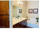 Bathroom featuring double sinks, wood cabinets, a soaking tub, and decorative accents at 6605 N 93Rd Ave # 1071, Glendale, AZ 85305