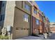 Multi-story townhome complex with garages and a contemporary design, enhancing curb appeal with a variety of neutral color accents at 6605 N 93Rd Ave # 1071, Glendale, AZ 85305