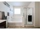 Bright, modern bathroom with a bathtub and walk-in shower with glass door at 6713 S 76Th Dr, Laveen, AZ 85339