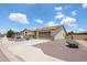 A well-maintained single story home with tan stucco, a stone facade, and desert landscaping at 6713 S 76Th Dr, Laveen, AZ 85339