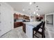 Spacious kitchen island with dark cabinets, light granite counters, and seating for casual dining at 6713 S 76Th Dr, Laveen, AZ 85339