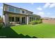 Spacious backyard featuring a covered patio, turf lawn and manicured landscaping at 7180 W Tombstone Trl, Peoria, AZ 85383